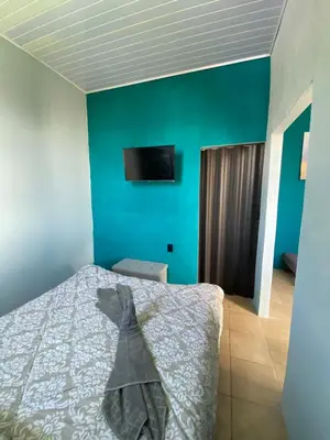 a bedroom with a bed and a blue wall at Los Sueños IyE 4 in Quepos