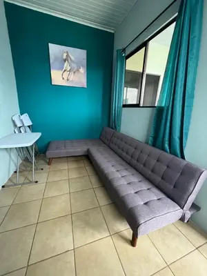 a couch in a room with a blue wall at Los Sueños IyE 4 in Quepos