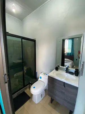a bathroom with a toilet and a sink and a shower at Los Sueños IyE 4 in Quepos