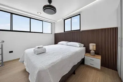 a bedroom with a large bed and some windows at Hotel Sabana Inn in San José