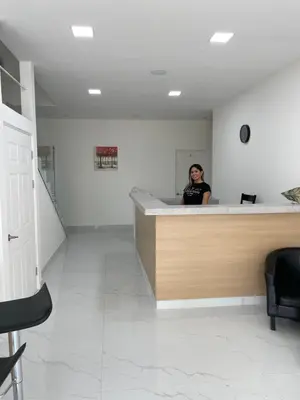 a woman sitting at a counter in a waiting room at Hotel Sabana Inn in San José