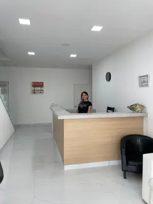 a woman standing behind a counter in a waiting room at Hotel Sabana Inn in San José