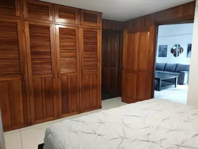 a bedroom with wooden cabinets and a bed and a couch at Your Perfect Home Away From Home! in San Ramón