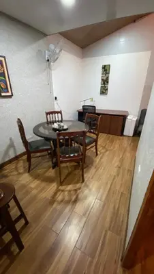 a dining room with a table and chairs and a piano at Casita Don Eliber in Fortuna