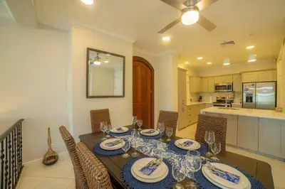 a dining room with a table and chairs and a kitchen at Colina 7C 3 bdr Garden View in Los Suenos in Herradura