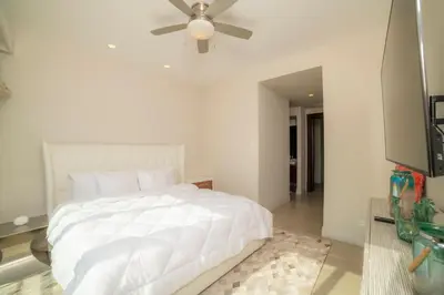 a bedroom with a white bed and a ceiling fan at Miramar 5D 3 bdr Ocean View in Los Suenos in Herradura