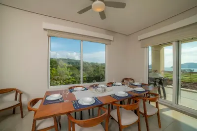 a dining room with a table and a large window at Miramar 5D 3 bdr Ocean View in Los Suenos in Herradura