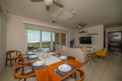 a dining room with a long table and chairs at Miramar 5D 3 bdr Ocean View in Los Suenos in Herradura