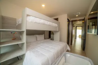 a bedroom with a bunk bed with white sheets at Miramar 5D 3 bdr Ocean View in Los Suenos in Herradura