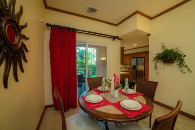 a dining room with a table and a red curtain at Veranda 5F 2 bdr Garden View in Los Suenos in Herradura