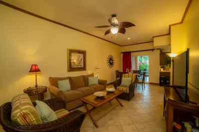 a living room with a couch and a table at Veranda 5F 2 bdr Garden View in Los Suenos in Herradura