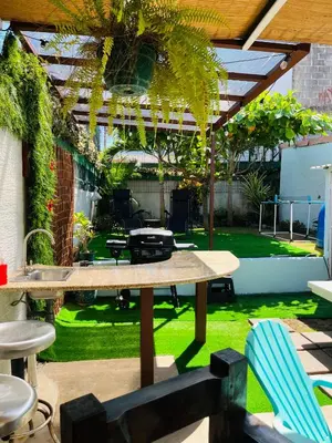 a patio with a table and chairs and a garden at CasaLu in Puntarenas