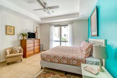 a bedroom with a bed and a chair and a window at Bahia Encantada I1 in Jacó