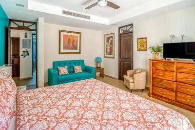 a bedroom with a bed and a couch and a tv at Bahia Encantada I1 in Jacó