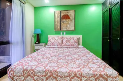 a green bedroom with a bed and a green wall at Bahia Encantada I1 in Jacó