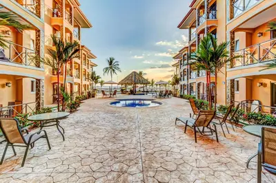 a courtyard at the resort with tables and chairs at Bahia Encantada I1 in Jacó