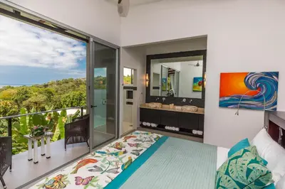 a bedroom with a balcony with a view of the ocean at Villa Ananda in Ballena