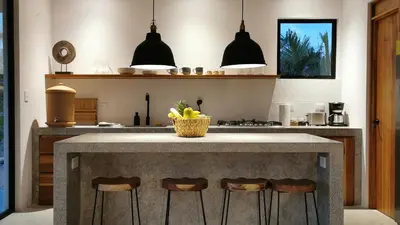 a kitchen with a island with bar stools at La Golfina Villa in Santa Teresa Beach