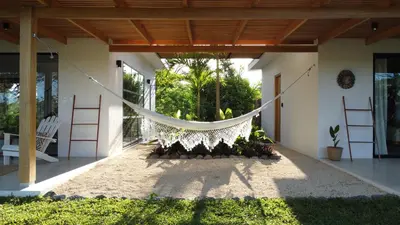 a hammock hanging from the porch of a house at La Golfina Villa in Santa Teresa Beach