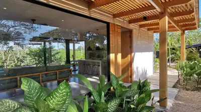 a house with a porch with plants in front of it at La Golfina Villa in Santa Teresa Beach