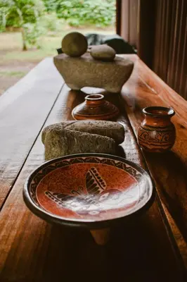 a wooden table with a plate and vases on it at Arenal Descanso in Fortuna
