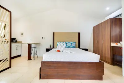 a bedroom with a large bed and a kitchen at Club Voca #9 in Coco
