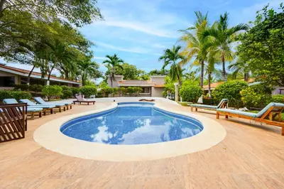 a swimming pool in a yard with chairs and trees at Club Voca #9 in Coco