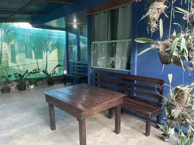 a wooden bench next to a blue wall with plants at Maricel House in San Rafael