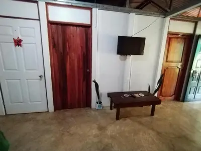 a room with a door and a table and a tv at Maricel House in San Rafael