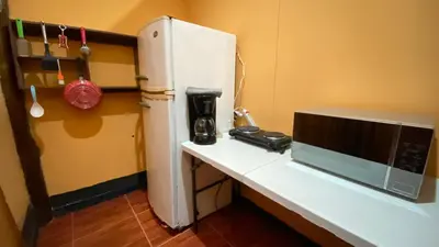 a kitchen with a white refrigerator and a microwave at Koi's House - Quebradillas de Dota in Santa María