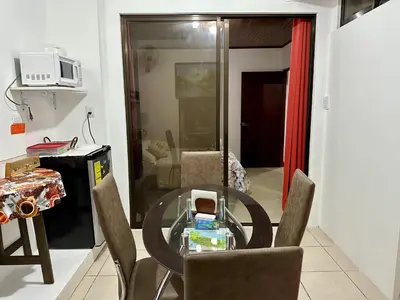 a glass table and chairs in a living room at Private bedroom 10 minutes from the SJO airport in Alajuela City