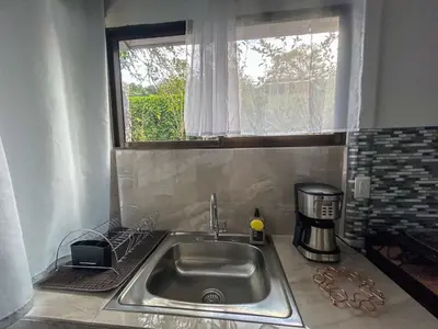 a kitchen counter with a sink and a window at Casa Urraca, Magnífica Vista al Océano Pacífico in Monteverde Costa Rica