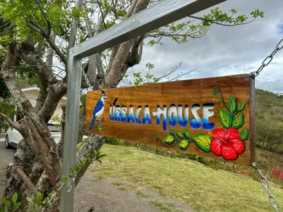 a sign for a tropical house with a blue bird on it at Casa Urraca, Magnífica Vista al Océano Pacífico in Monteverde Costa Rica