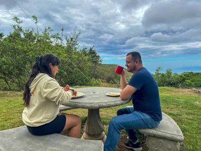 a man and woman sitting at a table drinking coffee at Casa Urraca, Magnífica Vista al Océano Pacífico in Monteverde Costa Rica