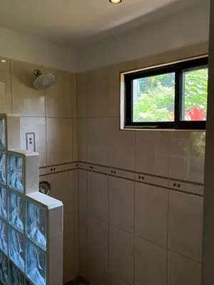 a bathroom with a shower and a window in it at Toucan Valley Resort at Osa Mountain Village in Agua Buena