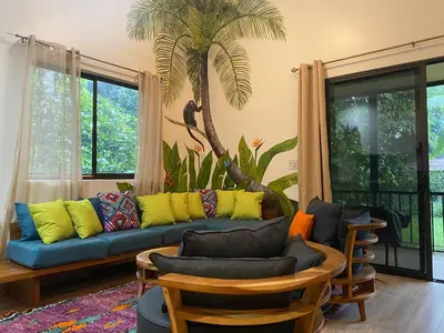 a living room with a blue couch with colorful pillows at Toucan Valley Resort at Osa Mountain Village in Agua Buena