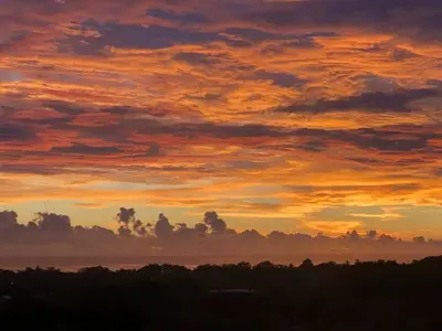a sunset over the water with clouds in the sky at Puesta del Sol in Quepos