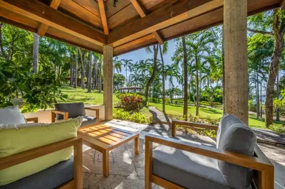 a porch with chairs and a table and trees at Casa Carmen in Potrero