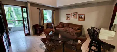 a living room with a couch and a table and chairs at Lovely Condo (8 people): Pools, Tennis Courts, BBQ in Manuel Antonio