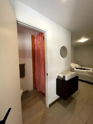 a bathroom with a sink and a red shower curtain at Nina´s - Juan Santamaria in Alajuela City