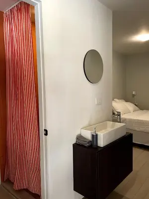 a bathroom with a sink and a bed at Nina´s - Juan Santamaria in Alajuela City