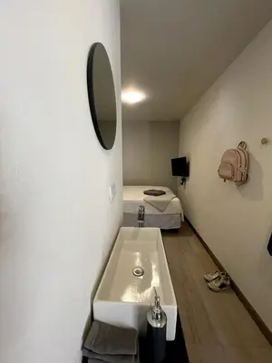 a bathroom with a sink and a bed in a room at Nina´s - Juan Santamaria in Alajuela City