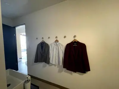 a wall with three jackets on hangers next to a sink at Nina´s - Juan Santamaria in Alajuela City