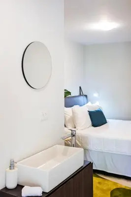 a bathroom with a sink and a bed at Nina´s - Juan Santamaria in Alajuela City
