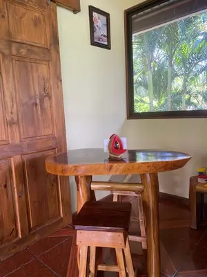 a wooden table in a room with a window at Jazlyn Lodge in Paquera