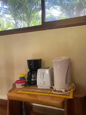 a counter with a coffee maker and a coffee pot at Jazlyn Lodge in Paquera