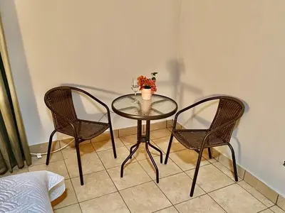 a table with two chairs and a vase on it at daBene - Bed & Breakfast in Alajuela City