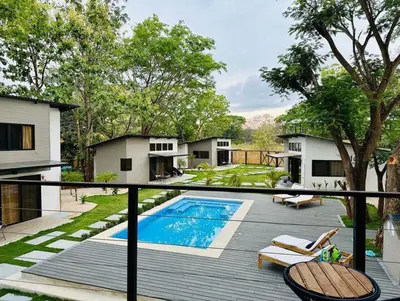 a deck with a swimming pool and chairs on a house at Blue Window Boutique Villas Hotel in Playa Junquillal