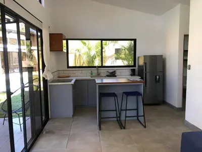 a kitchen with a counter and a sink and a refrigerator at Blue Window Boutique Villas Hotel in Playa Junquillal