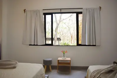 a room with two beds and a window at Blue Window Boutique Villas Hotel in Playa Junquillal